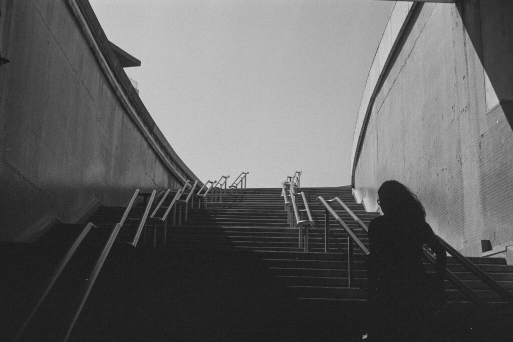 Black and white urban photograph of a person silhouetted on stairs in Porto, Portugal.